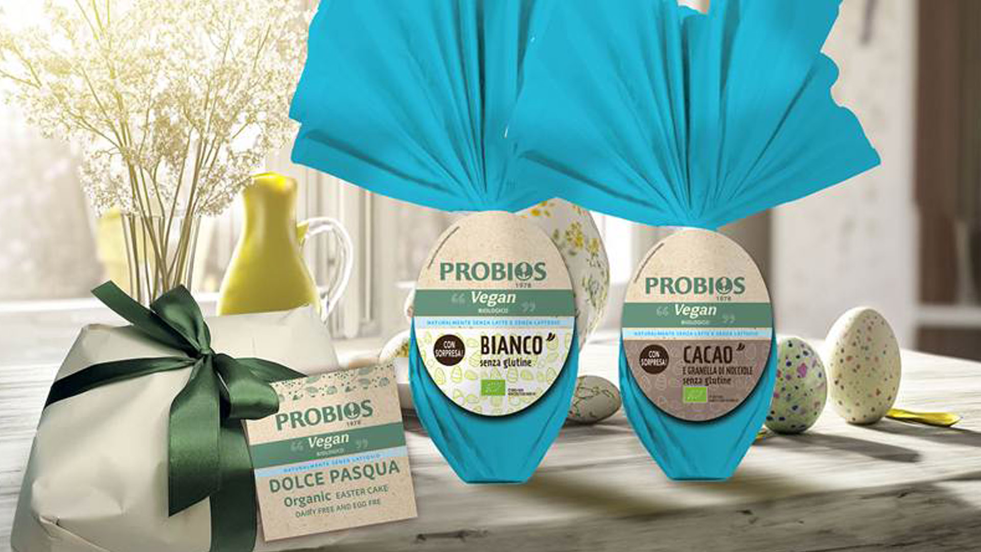 Dolci di Pasqua 2025 Probios: colomba vegan e uova di cioccolato biologiche senza glutine, nelle varianti bianco e cacao con granella di nocciole.